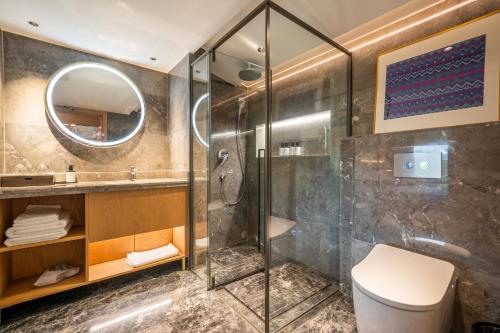 a bathroom with a shower and a toilet and a sink at Longji Vista Retreat--Panoramic View of Terrace, Sunrise ,Heated Pool & Affordable Luxury in Longsheng