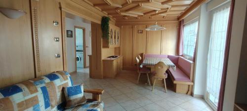 a living room with a pink couch and a table at Appartamenti Donatella in Cavalese