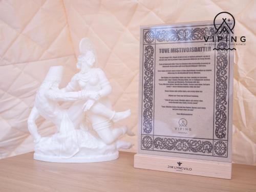 a white statue next to a sign on a table at Bramslev Bakker Naturhotel in Hobro