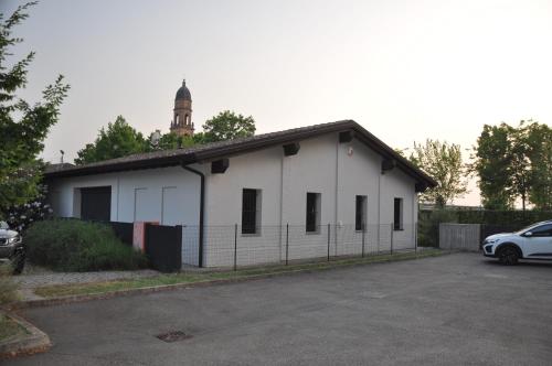 a white building with a clock tower on top of it at Minimal design villa Free parking Garden in Palazzina