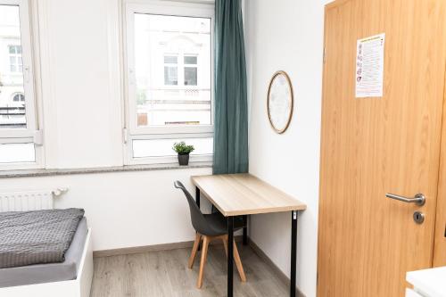 a room with a desk and a bed and a window at CosyHomes24 - centrally with balcony and garage - IL01b in Iserlohn