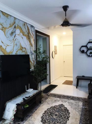 a living room with a couch and a tv at TFC Studio in Kuala Terengganu