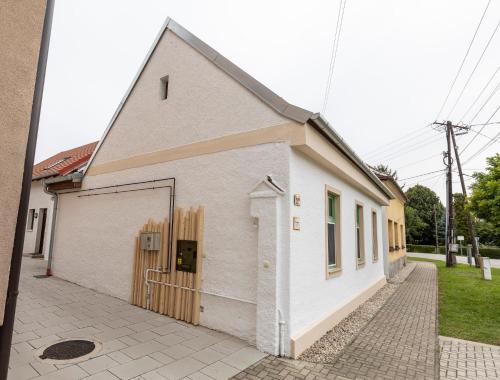 a white building with a door on the side of it at Park Apartman in Sarród