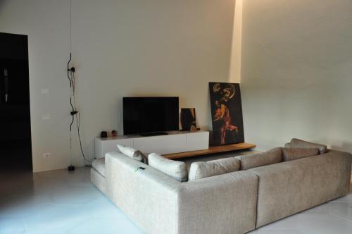 a living room with a couch and a tv at Minimal design villa Free parking Garden in Palazzina