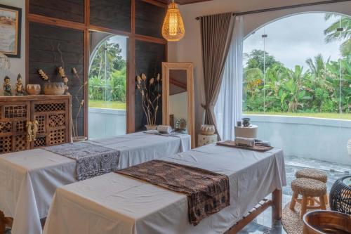 a room with two tables and a mirror at Casa Maddu in Tegalalang