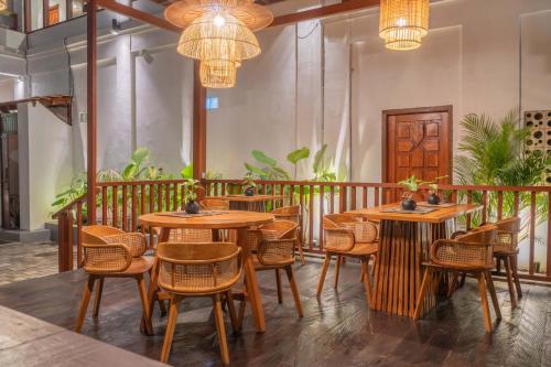 a restaurant with wooden tables and chairs and chandeliers at Casa Maddu in Tegalalang