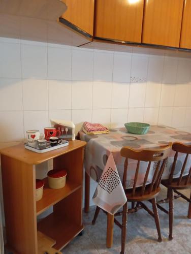 a kitchen with a table and two chairs and a table and a tableablish at PM 135 Corso Umberto Guest House in Cuglieri