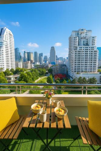 a table on a balcony with a view of a city at Executive Suite 2 Beds Nana BTS 5 mins in Bangkok