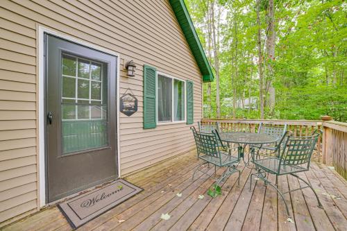 a patio with a table and chairs on a deck at 2 Blocks to Higgins Lake Family-Friendly Home in Roscommon