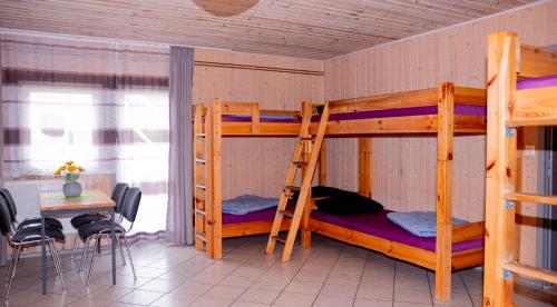 a bunk bed room with two bunk beds and a table at Hostel Waldhaus am Ferienpark Gruppenhaus in Mirow