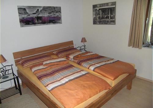 Un dormitorio con una cama grande con marco de madera. en Ferienwohnung am Rosengarten, en Füssen