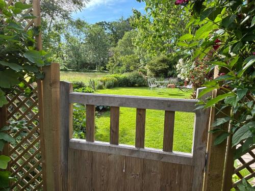 a wooden fence with a garden behind it at Pandy B&B in Dorstone