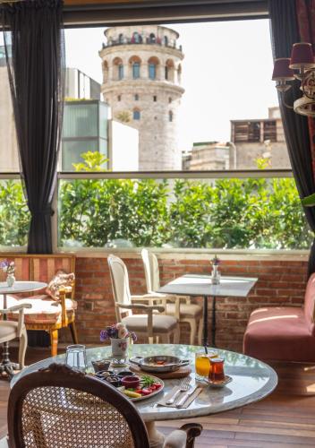 een kamer met een tafel en stoelen en een toren bij Meroddi Pera Flats in Istanbul