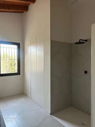 a bathroom with a shower with white walls and a window at Minimal design villa Free parking Garden in Palazzina