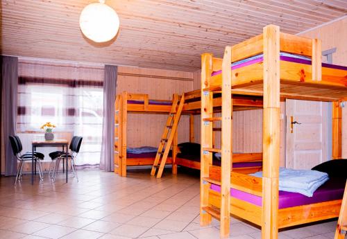 a room with two bunk beds and a table with chairs at Hostel Waldhaus am Ferienpark Gruppenhaus in Mirow