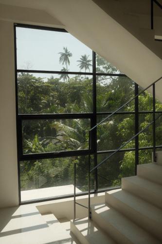 a staircase in a house with a large window at Nalu Mirissa in Mirissa
