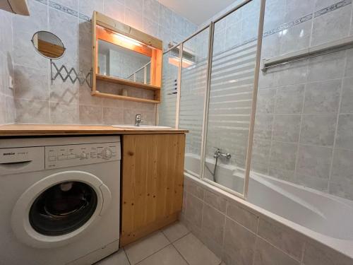 une salle de bain avec un lave-linge et une baignoire dans l'établissement Appartement T2 calme avec balcon, proche ski-bus et village - FR-1-624-37, à Samoëns