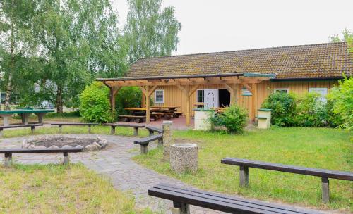 a pavilion with benches in front of a building at Hostel Waldhaus am Ferienpark Gruppenhaus in Mirow