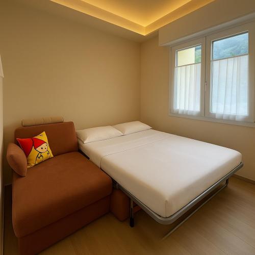 a bedroom with two beds and a couch at Tirano center-325m dal Bernina Express in Tirano