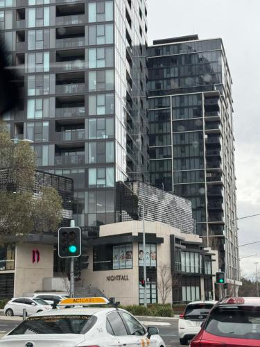 a green traffic light in front of a tall building at Modern Minimalist Apartment in Belconnen