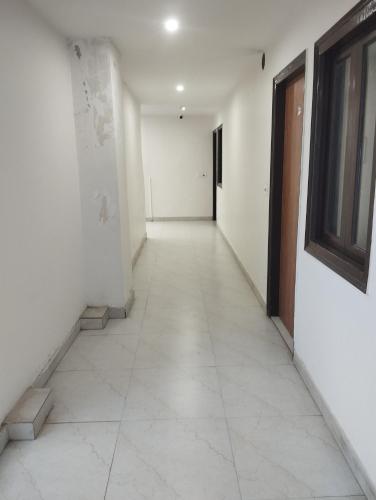 an empty hallway with white walls and a window at Fortune by guruji hospitality in New Delhi