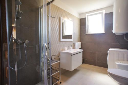 a bathroom with a shower and a sink and a toilet at Spacious apartment sleeps 4 by the beach in Medulin
