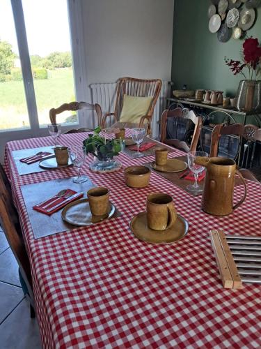 une table avec un chiffon de table rouge et blanc dans l'établissement Au Coeur du Bocage Vendéen, à Chantonnay