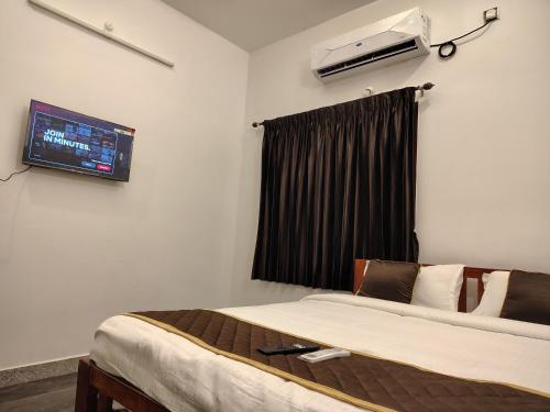 a bedroom with a bed and a tv on the wall at THE VILLA Pondicherry in Puducherry