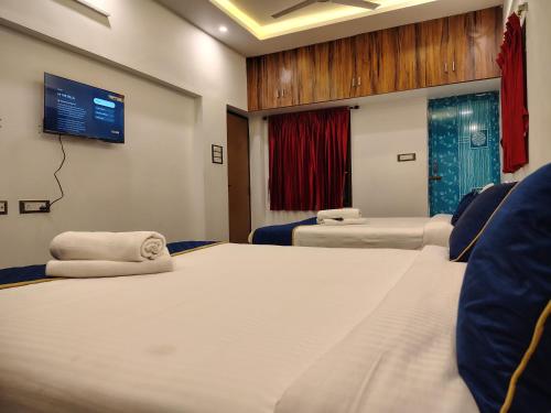 a room with two beds and a tv on the wall at THE VILLA Pondicherry in Puducherry