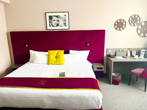 a bedroom with a large bed with a red headboard at Marivaux Hotel in Brussels