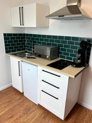 a kitchen with a counter top with a microwave at N6 - Petit studio proche du centre in Valenciennes