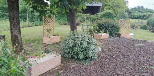 a garden with several plants in wooden boxes at Au Coeur du Bocage Vendéen in Chantonnay