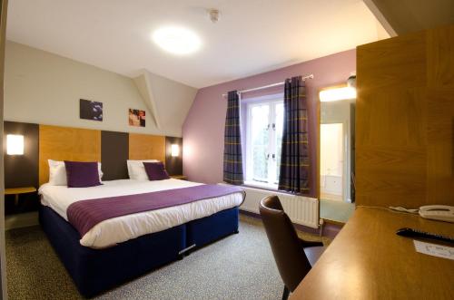 a hotel room with a bed and a window at The Corner House Hotel in Taunton