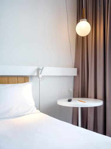 a bedroom with a bed and a table next to a bed at Hotel Ibis Krakow Centrum in Kraków