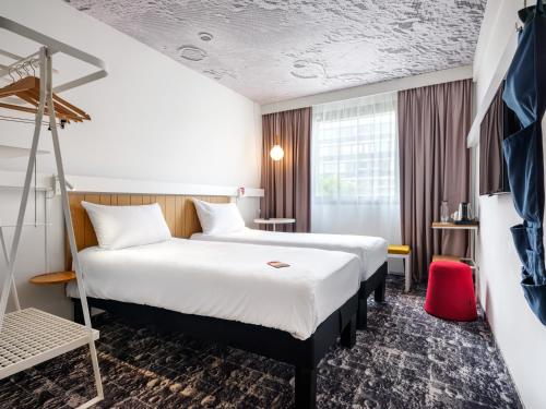 a hotel room with a large bed and a window at Hotel Ibis Krakow Centrum in Kraków