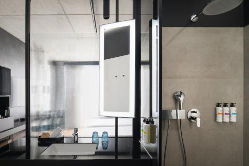 a bathroom with a sink and a shower at Pullman Zagreb in Zagreb