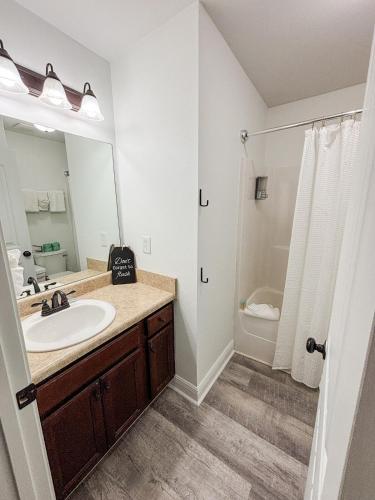 ein Badezimmer mit Waschbecken, Spiegel und Dusche in der Unterkunft FUNshine Cottage! in Foley