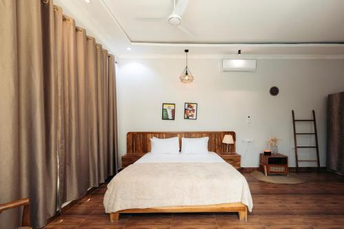 a bedroom with a large bed and curtains at Twin Villa Zulia by Zanzibar Stays - Private Pool Villa Jambiani in Jambiani