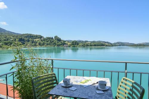 a table and chairs with a view of a lake at La Villa du Lac in Aiguebelette-le-Lac