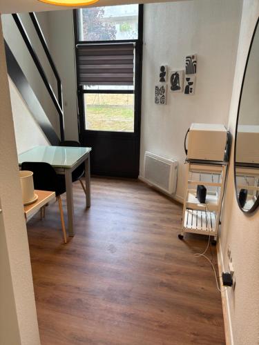 a room with a desk and a table and a door at Le Cocon des Géants in Toulouse