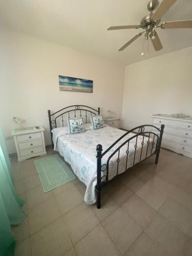 a bedroom with a bed and a ceiling fan at Green Apartment in La Maddalena