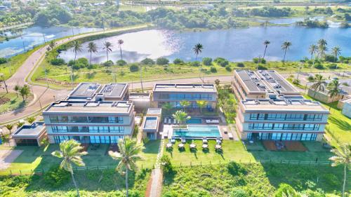 an aerial view of a resort with a body of water at Apartamento Pé na Areia Cond Alphaville Guarajuba in Camaçari