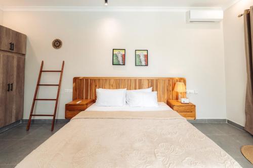 a bedroom with a large bed with a wooden headboard at Twin Villa Zulia by Zanzibar Stays - Private Pool Villa Jambiani in Jambiani