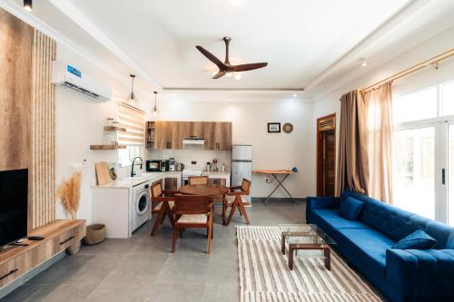 a living room with a blue couch and a kitchen at Twin Villa Zulia by Zanzibar Stays - Private Pool Villa Jambiani in Jambiani