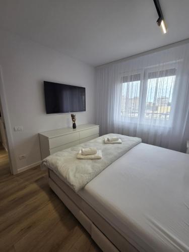 Un dormitorio blanco con una cama con dos toallas encima. en Vestiq ARAD, en Arad