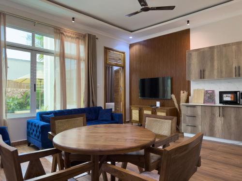 a living room with a table and a blue couch at Twin Villa Zulia by Zanzibar Stays - Private Pool Villa Jambiani in Jambiani