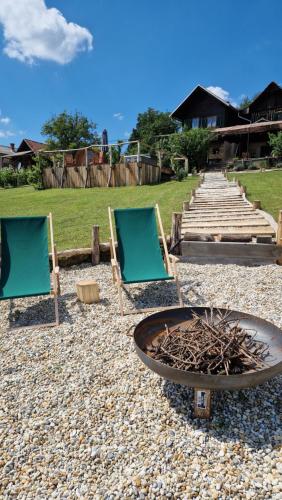 two lawn chairs and a fire pit with two chairs at Holiday House Clavis in Dobrovnik
