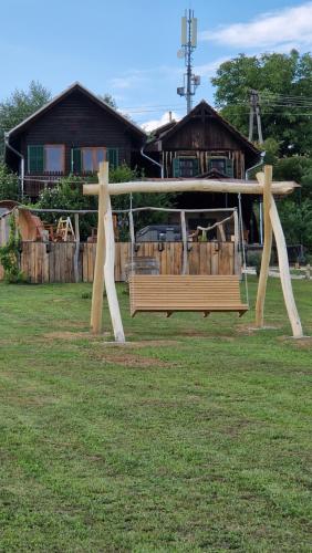 a wooden swing in a yard in front of a house at Holiday House Clavis in Dobrovnik