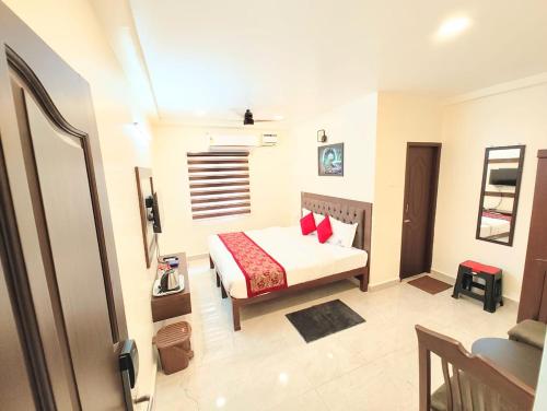 a bedroom with a bed with red pillows at MG Park in Chennai