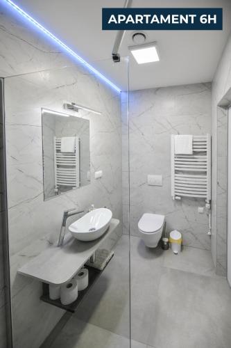 a white bathroom with a sink and a toilet at Słoneczne Wzgórze Zator in Zator